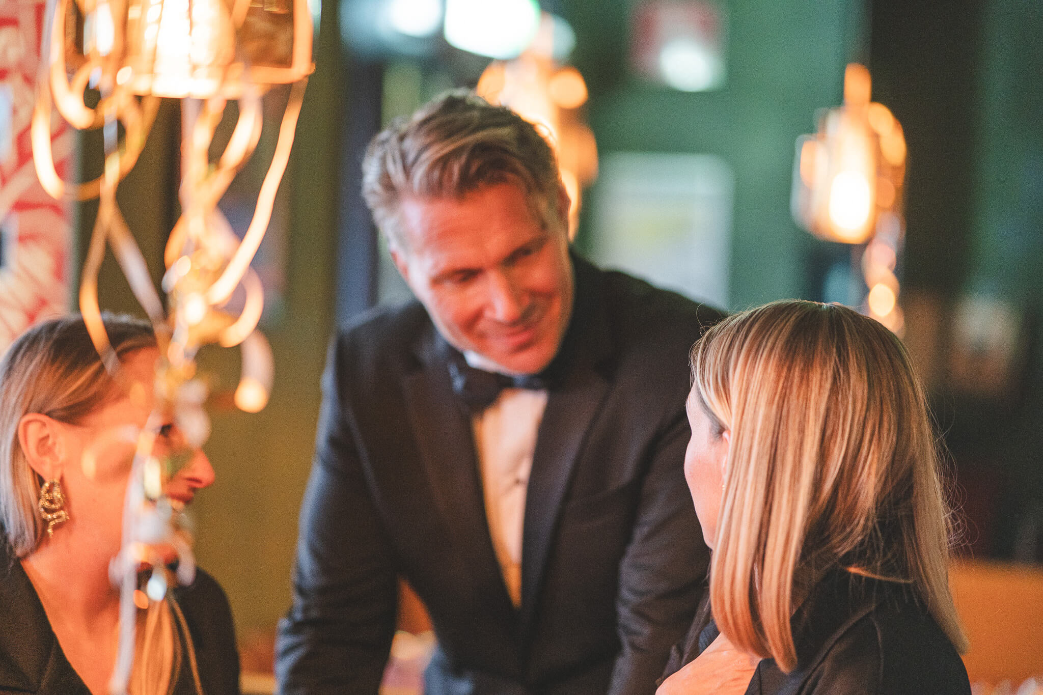 Tre festklädda personer samtalar